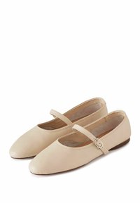 Bailarinas de piel beige con puntera afilada, tira al tobillo y forro interior texturizado. Superficie exterior lisa y diseño minimalista.