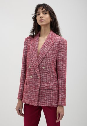 Doppeltblazer aus pinkem Tweed-Stoff mit strukturiertem Muster, Reverskragen und goldfarbenen Knöpfen. Maßgeschneiderte Passform mit Seitentaschen.