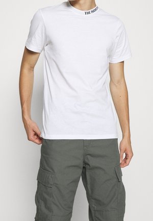 Witte katoenen t-shirt met korte mouwen, ronde hals en zwarte tekst "THE NORTH" op de kraag. Draag het met olijfgroene cargo broek.