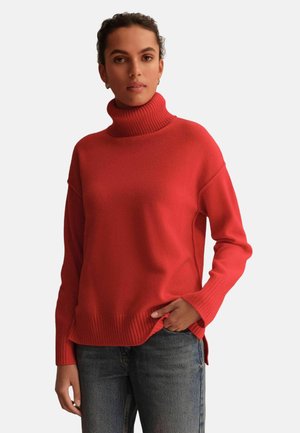 Roter Rollkragenpullover aus weichem Material, mit geripptem Kragen und Saum, locker geschnitten und mit seitlichen Schlitzen für zusätzlichen Komfort.