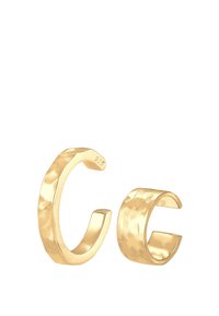 Goldfarbene Ohrcuffs mit gehämmertem Finish. Einer ist dicker mit einem geschwungenen Design; der andere ist schlanker, beide haben ein offenes Ende.