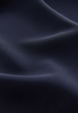 Sile tumesinine kangas peene ribikujulise tekstuuriga, mis langeb graatsiliselt, et näidata peent läiget ja sügavust. Muster ega täiendavad aksendid ei ole nähtavad.