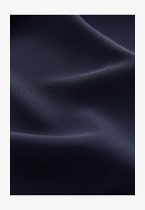 Sile tumesinine kangas peene ribikujulise tekstuuriga, mis langeb graatsiliselt, et näidata peent läiget ja sügavust. Muster ega täiendavad aksendid ei ole nähtavad.