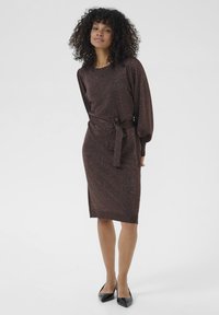 Robe en tricot métallique marron, longueur genou, avec un col rond, des manches longues et une ceinture à nouer à la taille pour une silhouette définie.