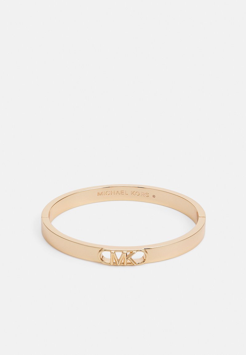 Kuldtoonist metallist käevõru, millel on sile, ümar serv. Ees on lõigatud "MK" logo aktsent. Sees on graveeritud brändi nimi.