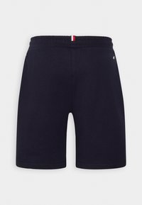 Pantalones cortos con cintura elástica azul marino y una pequeña pestaña con rayas rojas, blancas y azules en el centro de la parte trasera de la cintura.