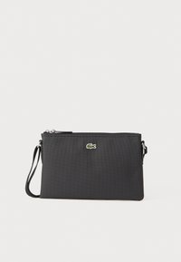 Borse da polso nera realizzata in materiale sintetico texturizzato. Presenta una chiusura con zip e un piccolo logo verde sulla parte anteriore. Include una tracolla.