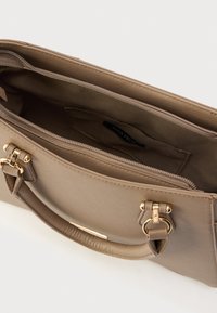 Beežist sünteetilisest materjalist käekott kulla toonide riistvaraga, tõmbluku sulgemise ja kahe käepidemega. Siseküljel on üks tõmblukuga tasku ja vooder heledamas toonis.