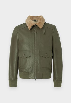Veste en cuir vert olive avec col en shearling beige, fermeture éclair à l'avant, deux poches à rabat avec bouton et poignets et taille en tricot.