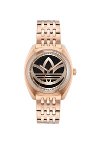 Montre en or rose avec un cadran noir présentant un grand design de logo. Elle possède un bracelet en métal à maillons et une forme de boîtier géométrique. Verre de forme ronde.