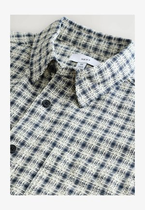 Ternede skjorte i marineblå og cremede farver. Blødt stof med et struktureret mønster, der har en standard krave og sorte knapper.