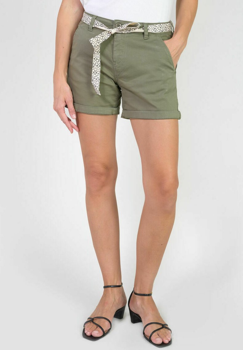 Shorts en coton vert olive avec des ourlets retroussés, dotés d'une ceinture à motifs blancs, de poches avant et d'une coupe ajustée. Associés à des talons noirs à brides.