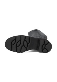 Zwarte laarzenzool met een gestructureerde rubberen grip, voorzien van een geribbelpatroon en gebogen lijnen voor flexibiliteit. Ontworpen voor tractie en duurzaamheid.