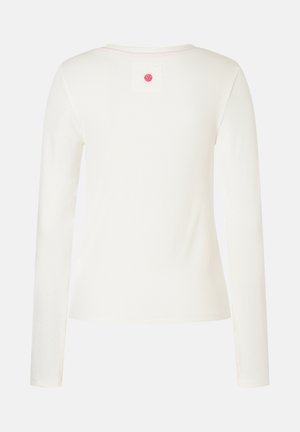 Weißes langärmliges Ripp-Shirt mit Rundhalsausschnitt, von hinten gezeigt, mit einem kleinen rosa runden Patch unter dem Kragen.