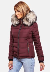 Burgundy puffer jacket with a detachable faux fur collar, zippered pockets, and ribbed cuffs, featuring a quilted texture and fitted design.