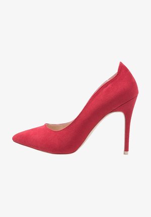 Red suede high heel shoe with a pointed toe and a sleek silhouette. Features a thin stiletto heel and inner lining for comfort.