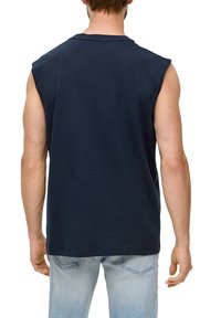 Donkerblauwe mouwloze t-shirt van katoen, met een ontspannen pasvorm, ronde halslijn en een gladde textuur. Achteraan zijn de schoudernaden zichtbaar.