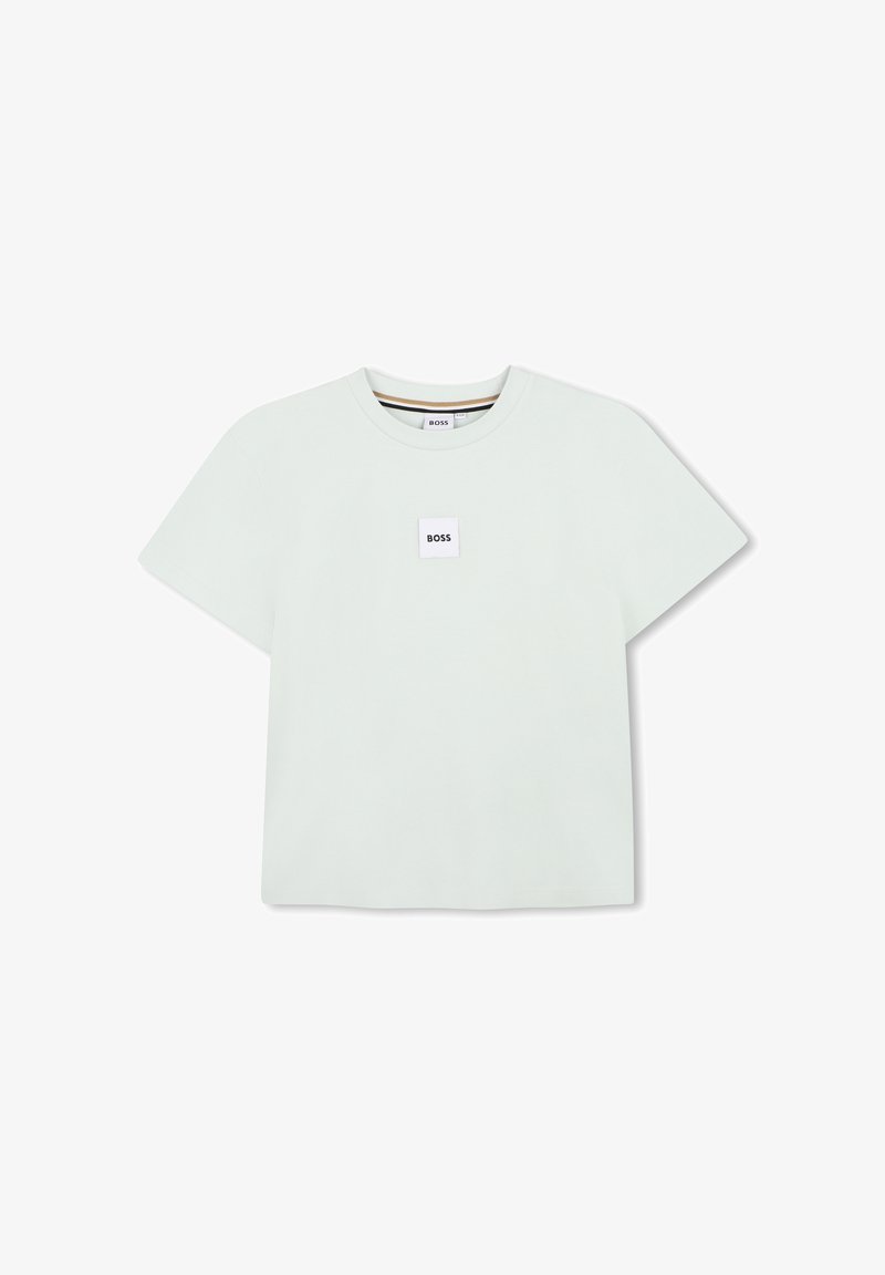 T-shirt vert menthe clair à manches courtes en coton doux, avec un patch logo carré sur la poitrine et des surpiqûres contrastées au niveau de l'encolure.