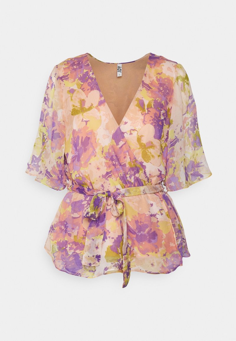 Blouse transparente à motifs floraux violets, roses et jaunes, manches courtes évasées, col en V et ceinture nouée à la taille sur fond blanc.