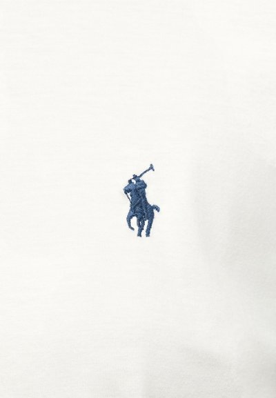 Μπλε κεντημένος παίκτης πόλο πάνω σε άλογο που κρατάει μαλέτα σε λευκό φόντο υφάσματος.