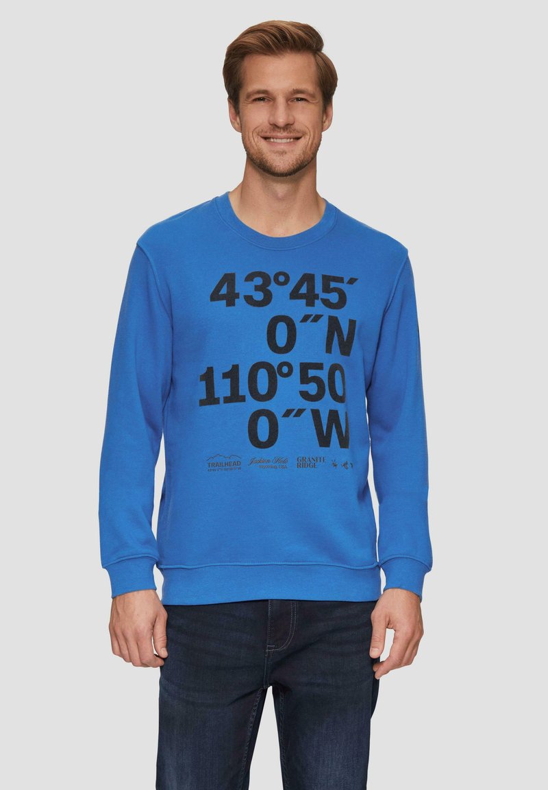 Niebieska bluza z okrągłym dekoltem, z czarnymi nadrukowanymi współrzędnymi i logo. Wykonana z miękkiego, teksturowanego materiału z prążkowanymi ściągaczami.