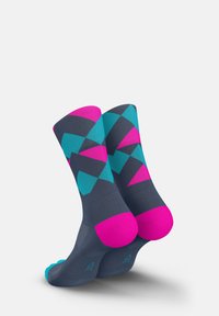 Bunte Socken mit einem geometrischen Muster in Türkis, Dunkelgrau und Pink, mit kontrastierenden Zehen- und Fersenbereichen in leuchtendem Pink.