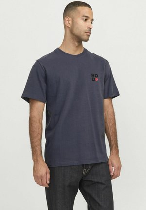 T-shirt di cotone blu navy con collo rotondo, maniche corte e un logo rettangolare in nero e rosso sulla parte sinistra del petto.