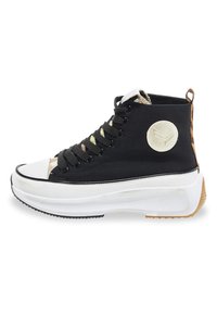 Zapatilla alta negra con una puntera blanca, cordones en la parte delantera, parte superior de tejido negro texturizado y panel trasero estampado. Suela blanca gruesa.