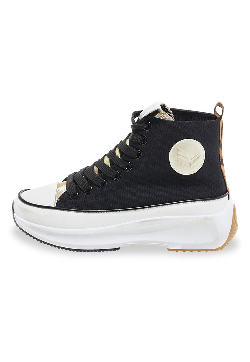 Zapatilla alta negra con una puntera blanca, cordones en la parte delantera, parte superior de tejido negro texturizado y panel trasero estampado. Suela blanca gruesa.