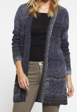 Long cardigan en tricot bleu profond et gris, avec une ouverture à l'avant, des manches longues et des poches latérales. Texture douce, coupe décontractée.