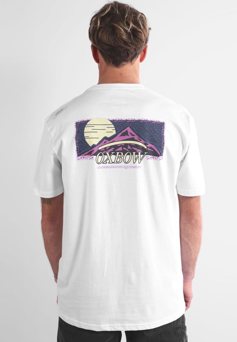 T-shirt blanc à manches courtes présentant un graphique coloré de montagne avec une lune, et "OXBOW SNOWBOARDING EQUIPMENT" imprimé en dessous.