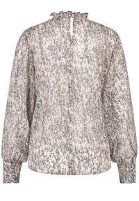 Blouse à manches longues rose pâle avec un motif gris tacheté. Présente un col volanté et des poignets élastiques avec des détails boutons.