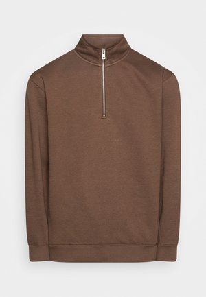 Brauner Pullover mit langen Ärmeln, hohem Kragen und Viertel-Reißverschluss aus weichem Stoff. Abgeschlossen mit gerippten Bündchen und Saum.