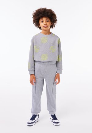 Sweatshirt gris avec motif géométrique vert lime, associé à un pantalon cargo gris assorti. Comprend une taille élastique et des poches latérales.