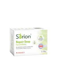 Reparaturseifenverpackung, weiß mit grünen Akzenten, zeigt ein geometrisches Muster. Enthält zwei 100g Riegel für trockene, empfindliche Haut. Beinhaltet ein Zertifizierungslogo.