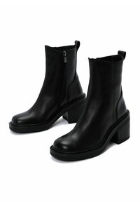 Black leather ankle boots with a block heel, vertical zipper, and minimal design. Features a smooth texture and rounded toe.