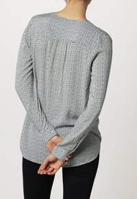 Koszula z długim rękawem w zielono-białą kratę, z okrągłym dekoltem i zapięciem na guziki przy mankietach, z marszczonym detalem na plecach.