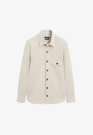 Camicia beige chiaro a maniche lunghe con colletto, bottoni neri sul davanti e sulla patta della tasca sul petto sinistro, esposta su sfondo bianco.