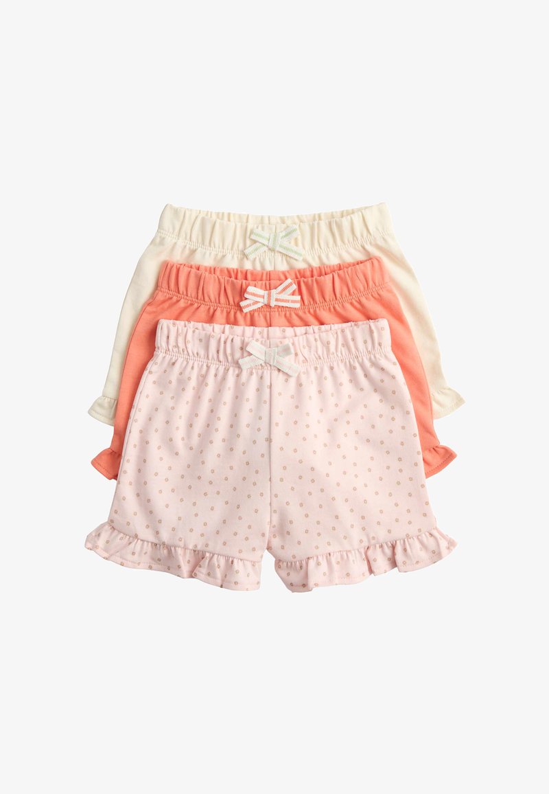 Three pairs of children's shorts in pink with small dots, coral, and cream, all with elastic waistbands and small decorative bows.