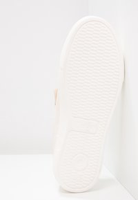 Semelle de basket en caoutchouc blanc avec un motif texturé. Présente un bord lisse légèrement surélevé, marqué du nom « Gabor ».