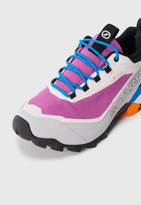 Lilla og grå tur-sko med svart såle, lyseblå snører, Gore-Tex-merke og Scarpa-logo på siden.