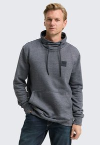 Grijze sweatshirt met een kraag, trekkoorden en voorzak. Bevat een klein zwart logolabel. Gedetailleerde textuur zichtbaar.