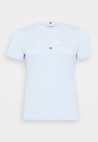 T-shirt en coton bleu clair avec un col rond, des manches courtes, et un texte imprimé blanc "New York Tommy Hilfiger" sur le devant. Design simple.