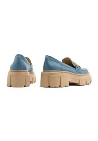 Niebieskie skórzane loafersy na platformie z solidną beżową podeszwą, charakteryzujące się haftowanym wzorem i złotymi akcentami hardware na froncie.