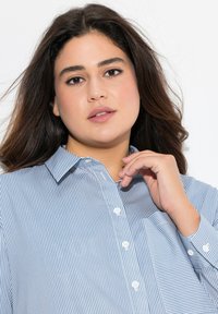 Ljusblå och vit randig knapp-up skjorta med krage, bröstficka och lång ärm. Slät tyg med en avslappnad passform.