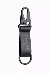 Sort læder nøglering med metalclip og nøglering. Har prægede "OMBRE 1985"-bogstaver og en glat, mat overflade.