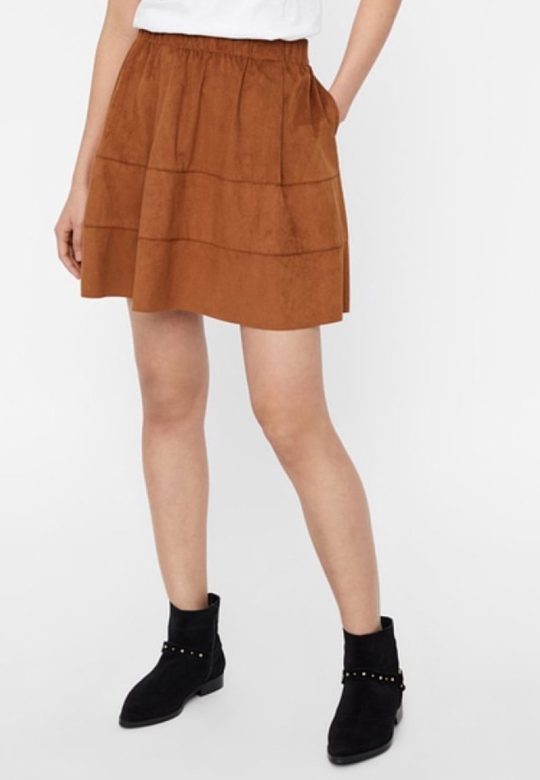 Brauer Wildlederrock mit elastischem Bund und zwei Seitentaschen, ausgestattet mit gestuften Lagen und einem ausgestellten Design, kombiniert mit schwarzen Stiefeletten.