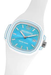 Reloj octogonal con correa de silicona blanca, esfera texturizada azul, marcadores de hora plateados y pantalla de fecha. Presenta "Swiss Made" y logo.