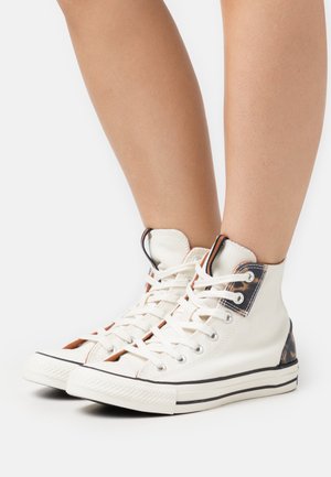 Weiße High-Top-Sneaker mit einem Obermaterial aus Canvas und braunen Tierdruckakzenten. Verfügt über Metalldurchzüge, flache Schnürsenkel und eine Gummisohle.