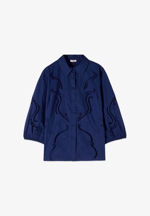 Granatowa koszula na guziki z bufkami o długości 3/4 oraz czarnymi haftowanymi kwiatowymi i spiralnymi wzorami wycięć.